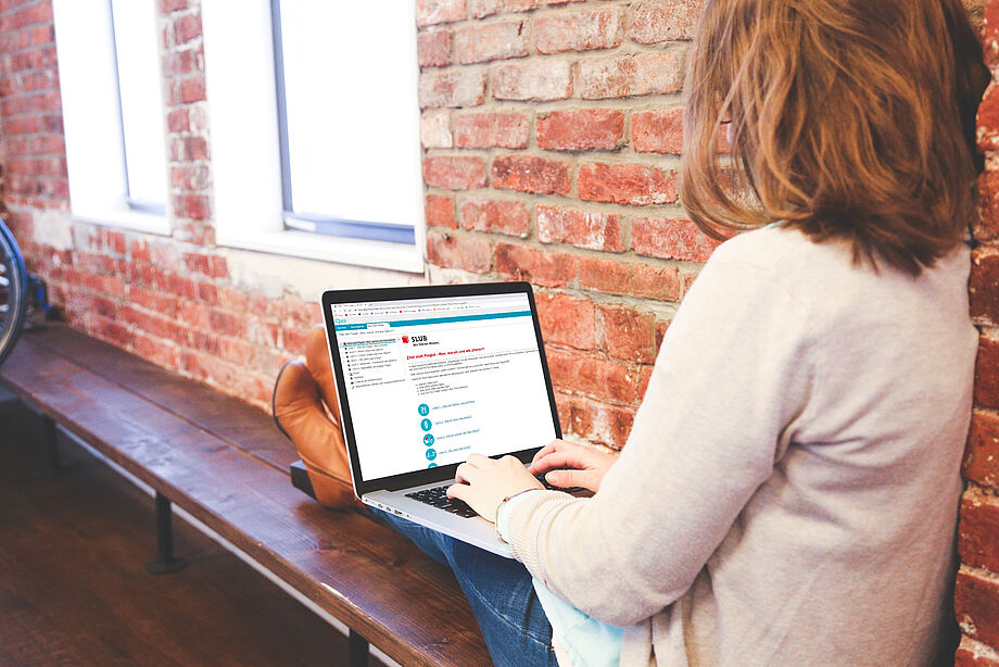 Link zur Seite über die SLUB Tutorials Frau sitzt am Laptop - Link zur Seite über die SLUB Tutorials