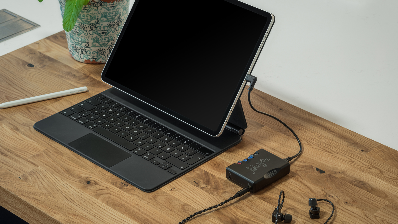 the chord mojo 2 portable dac connected to a tablet and earphones