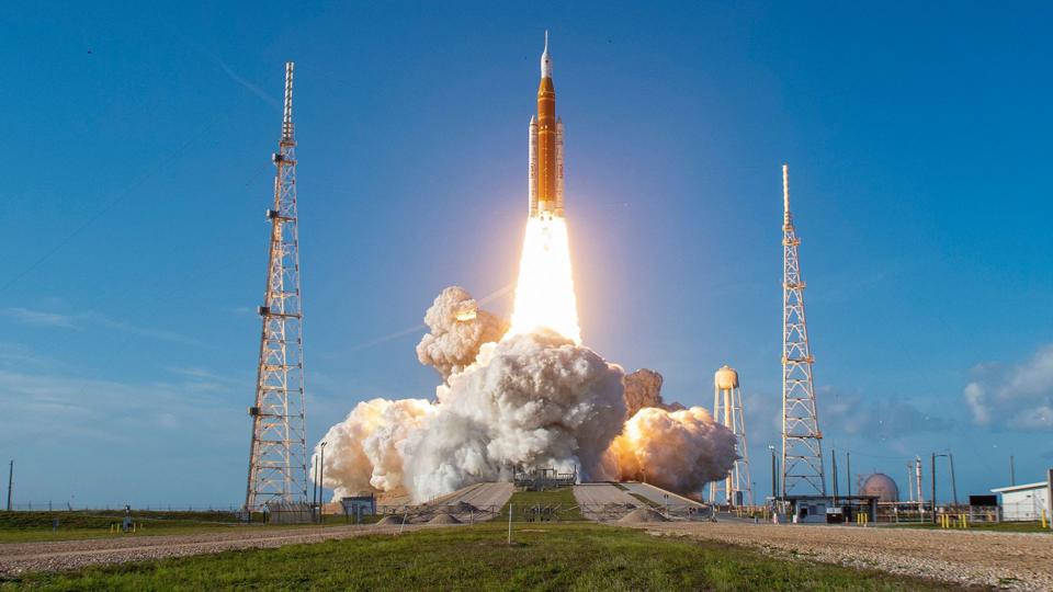 Rocket takes off from launch pad with huge trail of flames and smoke behind it